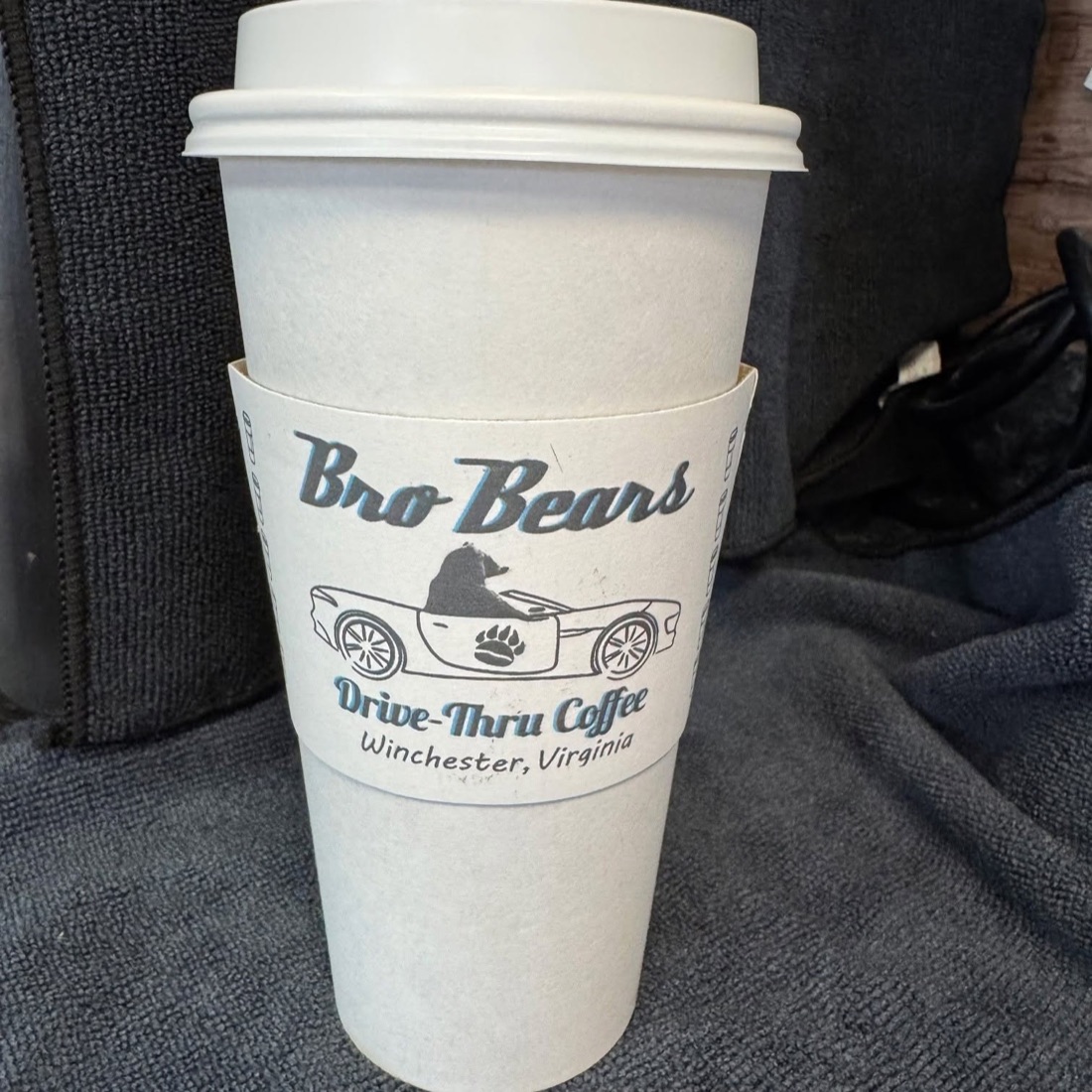 A hand holding a branded white Bro Bears hot cup